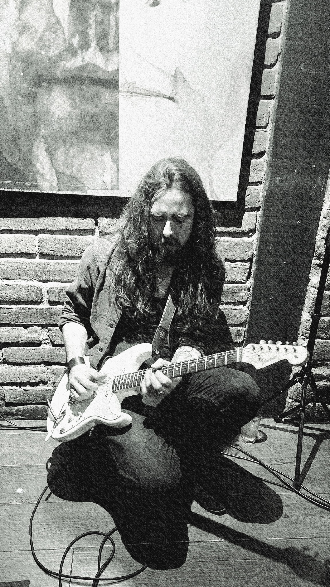 Nicolas playing guitar live in black and white