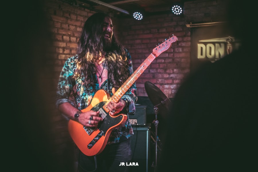 Nicolas playing a Telecaster on a brick stage