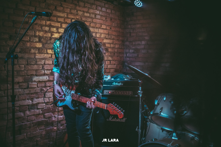 Nicolas playing live on a brick stage