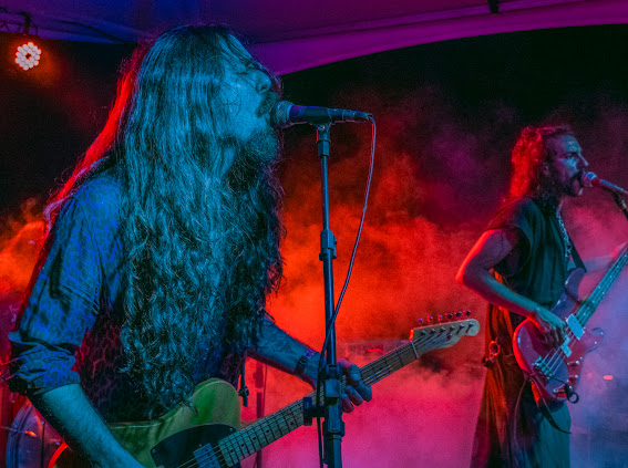 Nicolas singing and playing guitar in colored stage light